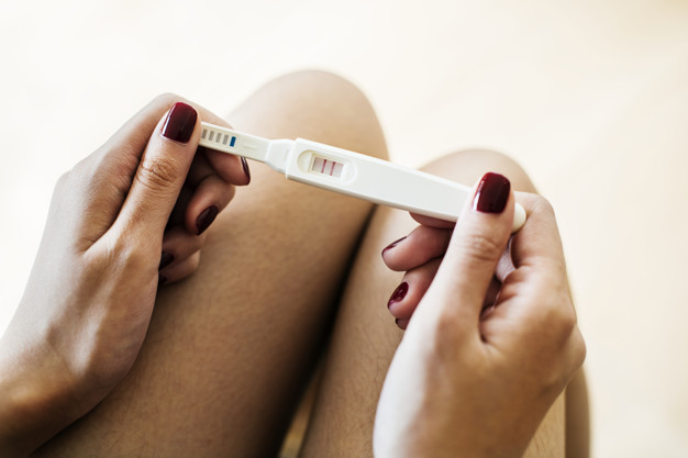 Kobieta trzyma pozytywny test ciążowy